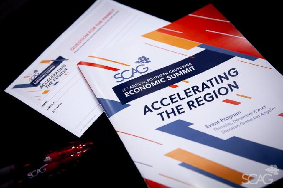 "Regional Briefing Book" and other event materials on a table.